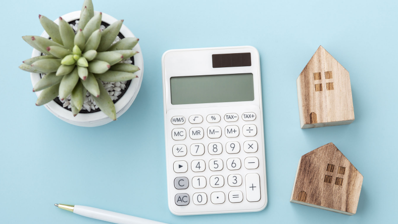 close up of calculator and small house keychain