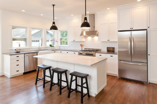 open concept kitchen with hardwood floors and stools
