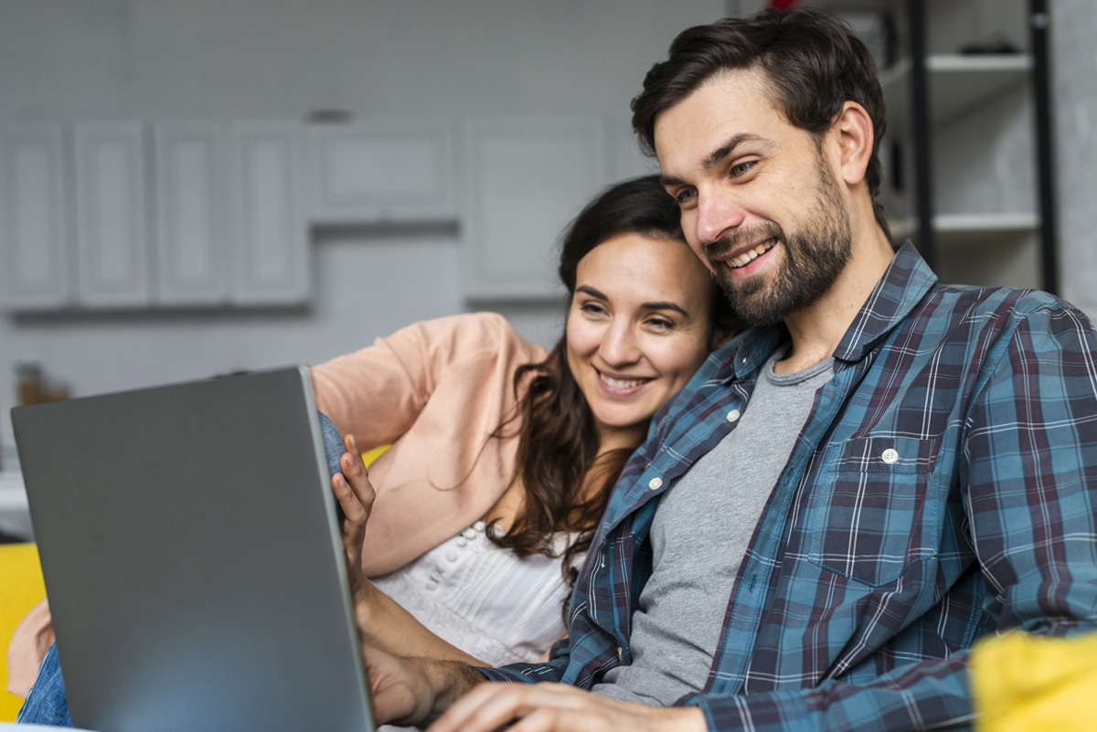 father and child looking at each other smiling while on laptop