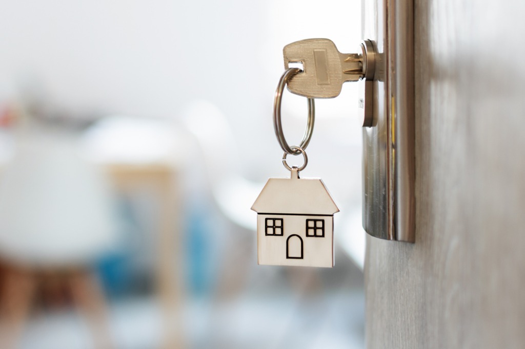 close up of calculator and small house keychain