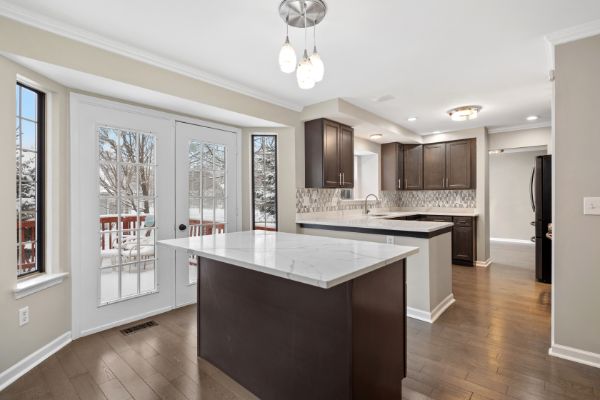 large living room with wood floors and steps to kitchen