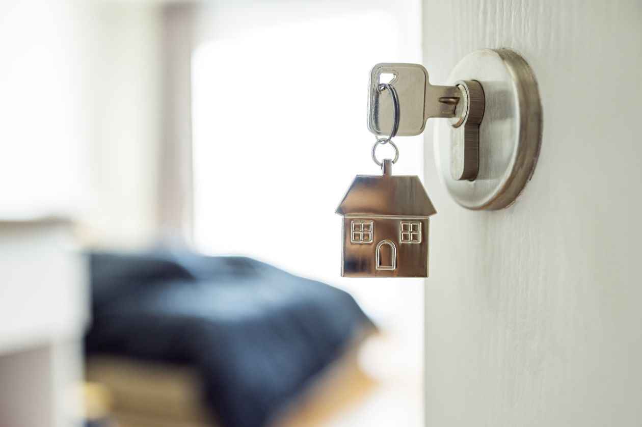 small house on keychain laying beside calculator